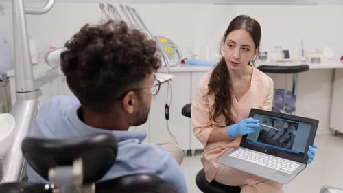 Dentist Shows Patient X-Rays on Laptop