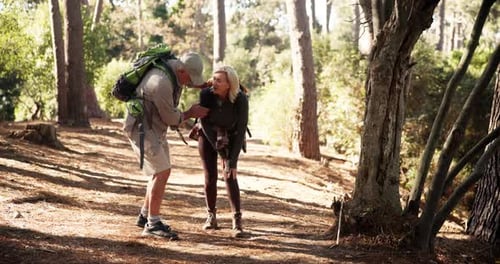 Nature, injury and couple hiking in forest on vacation, holiday or weekend trip together