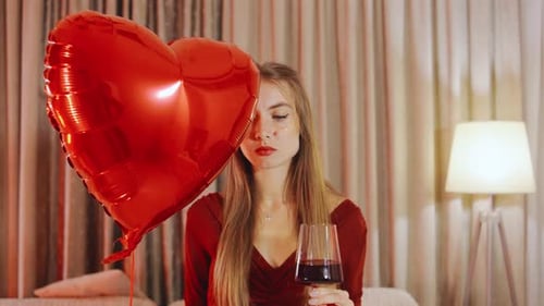 Sad Woman with Heart Balloon and Red Wine