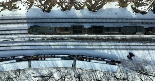 O
vagão de trem com motor a diesel passa por um acidente descarrilado nos trilhos da ferrovia. Neve aérea de inverno v