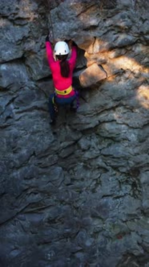 Aerial Footage of Young Brunette Sportswoman Climbing on Mountain Stone Sharp Rock Hiking Trail
