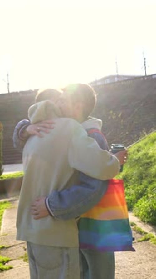 Gay Couple Holding Hands and Embracing in Park