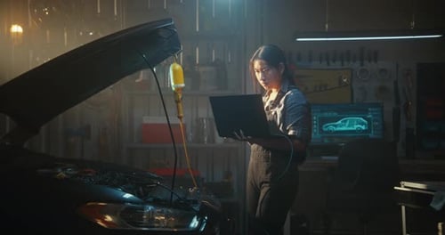 Mechanikerin behebt Probleme mit dem Automotor mit Diagnosesoftware