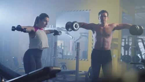 A Couple is Doing Sports and Training Together in the Gym