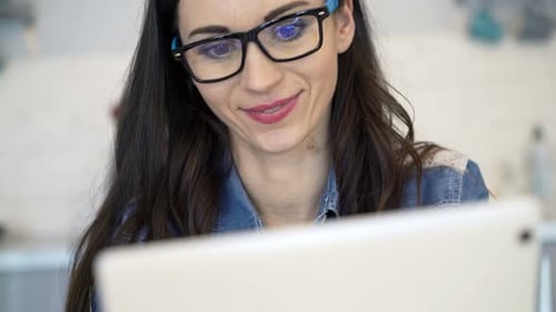 Junge, glückliche Frau surft zu Hause auf einem Tablet-Computer im Internet der 30er Jahre