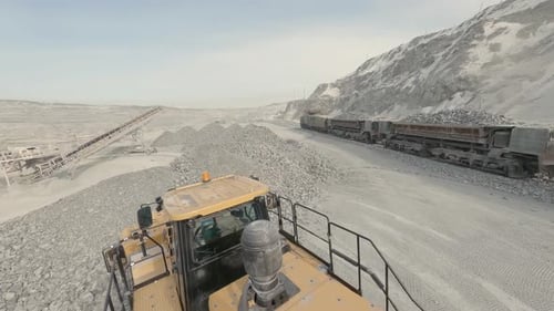 FPV drone view of Wheel loader in a quarry is loading wagons with rubble 09