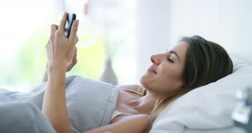 Woman in Bed Using Cell Phone