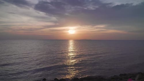 Dramatic sea sunrise. Burning sky and shining golden waves. Evening sunset over ocean. Reflection of