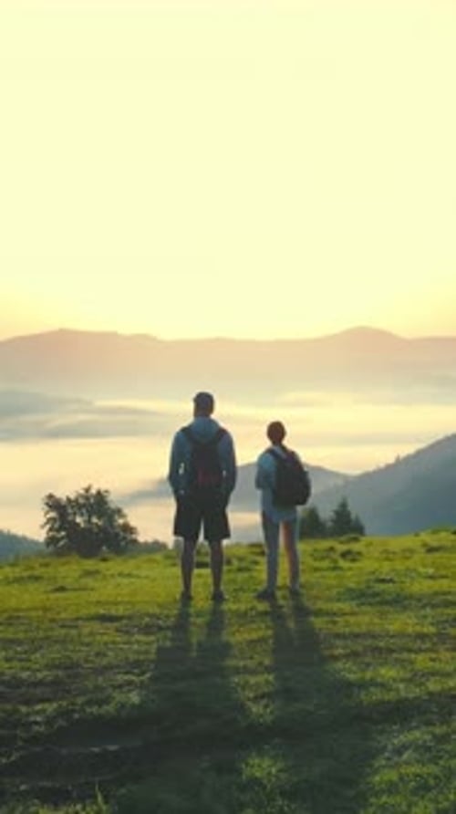 Sunrise on Top of the Mountain Man and Woman Admire the Beautiful Landscape Morning Fog in a