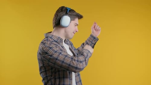 Mature 30s Positive Man Listening Music Enjoying with Headphones Yellow Studio