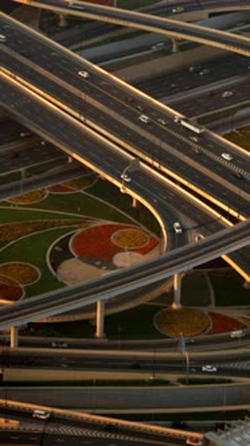 Aerial View of a Vibrant Urban Highway Intersection with Colorful Landscaping and Traffic