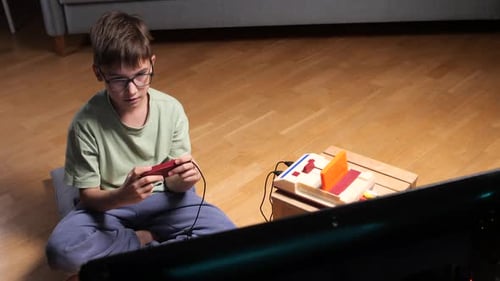 Boy Plays Retro Video Game at Home