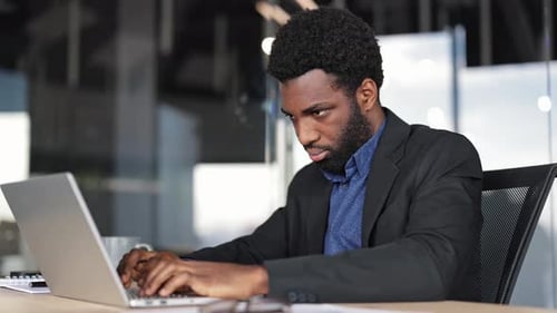 Businessman Working on Laptop in Modern Office
