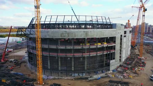 Potentes grúas cerca del edificio del estadio deportivo, vista aérea
