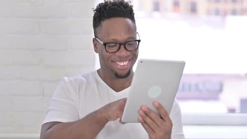 Smiling Man Using Tablet Device Indoors