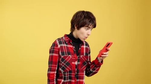 Surprised Woman Looks at a Smartphone