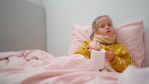 Girl Lying in Bed with Toilet Paper Roll