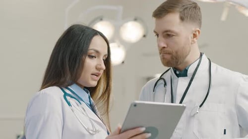 Doctors Consulting Over Tablet in Bright Hospital Setting