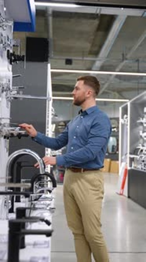 Handsome Man Chooses a Water Tap in Plumbing Store Vertical Video