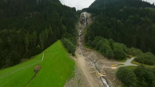 Aerial View of Lush Green Alpine Landscape with Waterfall