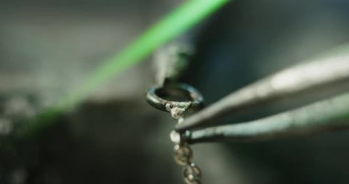 Slow motion macro of goldsmith working on a handmade jewelry bracelet chain of precious metal whit