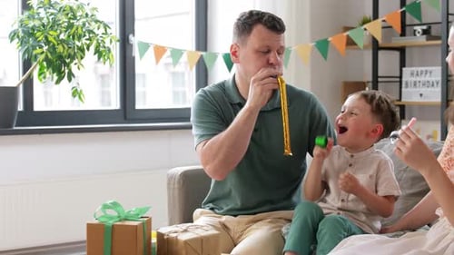 Family Celebrates Birthday with Party Blowers at Home
