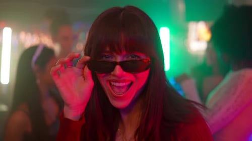 Stylish young woman dancing at a neon nightclub party