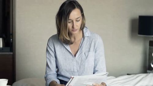Young Pretty Businesswoman Reading Magazine and Drinking Tea During Breakfast in Hotel Adult