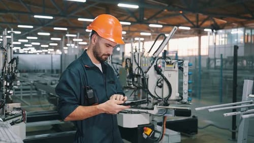Machinery conception, operator is with tablet. Man is working in the modern factory.