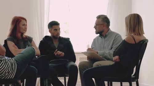 Young People Listening to Speaking Therapist During Psychotherapy in the Office Advise