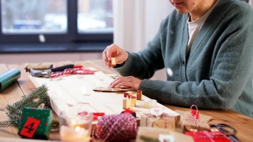 Woman Making Holiday Decorations at Wooden Table