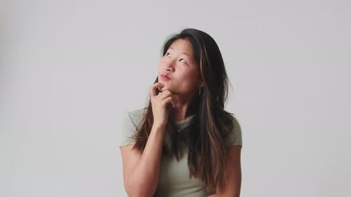 Young woman pensive and dreamy isolated over white background in studio