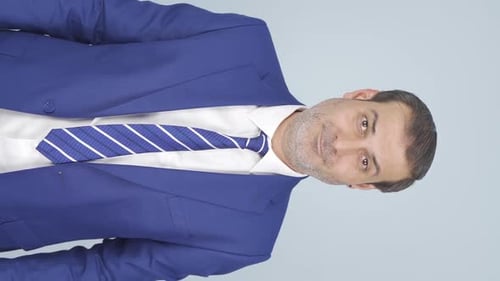 Enthusiastic Man in Blue Suit Giving Thumbs Up