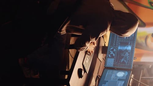 Hooded Figure Works at Computer in Graffiti Art Room