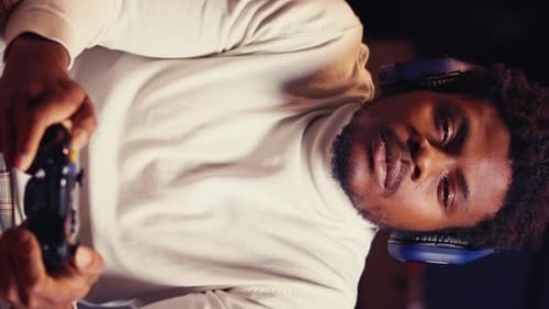 Young Adult Gaming with Controller and Headphones