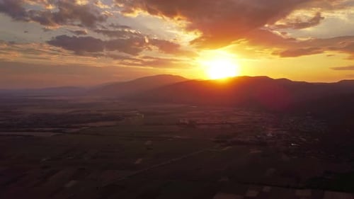 Sunset Over Fields and Mountains