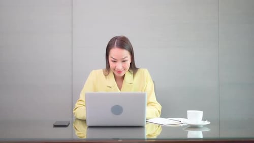 Woman Working on Laptop in Bright Office