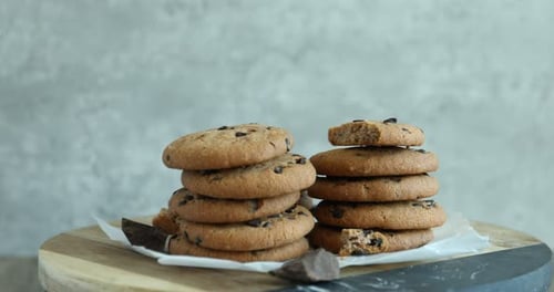 Chocolate Chip Cookies Stacked High with Hand Taking Cookie
