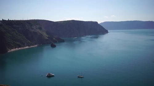 Luftbild von oben auf ruhiges azurblaues Meer und vulkanische Felsküsten