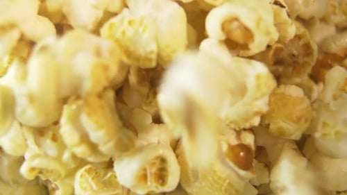 Popcorn falling into big bucket, delicious close-up beauty shot