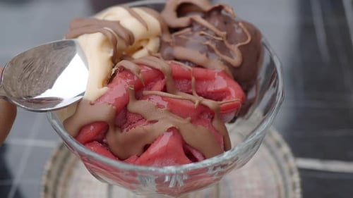 Delicia cremosa de helado servida con un chorrito de chocolate