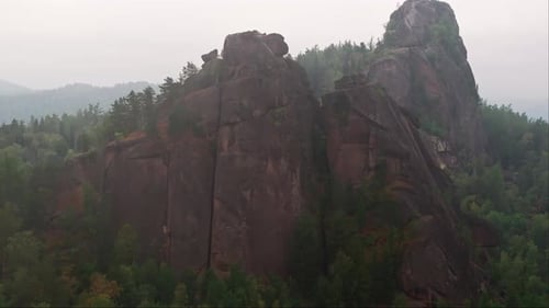 A Majestic Rock Formation Standing Tall Amongst the Enchanting Forest Trees