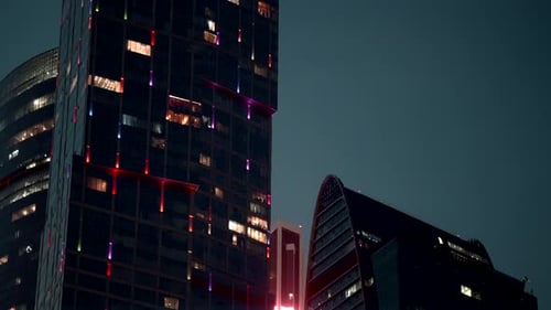 Bottom View of High Rise Buildings with Glowing Windows on Sunset Sky Background Action Beautiful