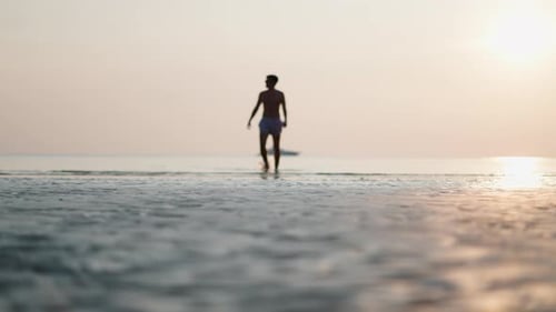 Young Man Relaxing in the Calm Waters of the Ocean at Sunset