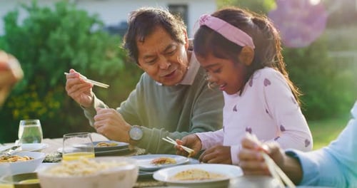 Family Enjoys Lunch Together Outdoors in Sunny Garden