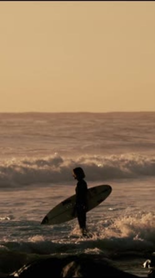 Die Silhouette des Surfers bei Sonnenuntergang