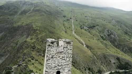Medieval Stone Tower Guarding Winding Mountain Path in Georgia