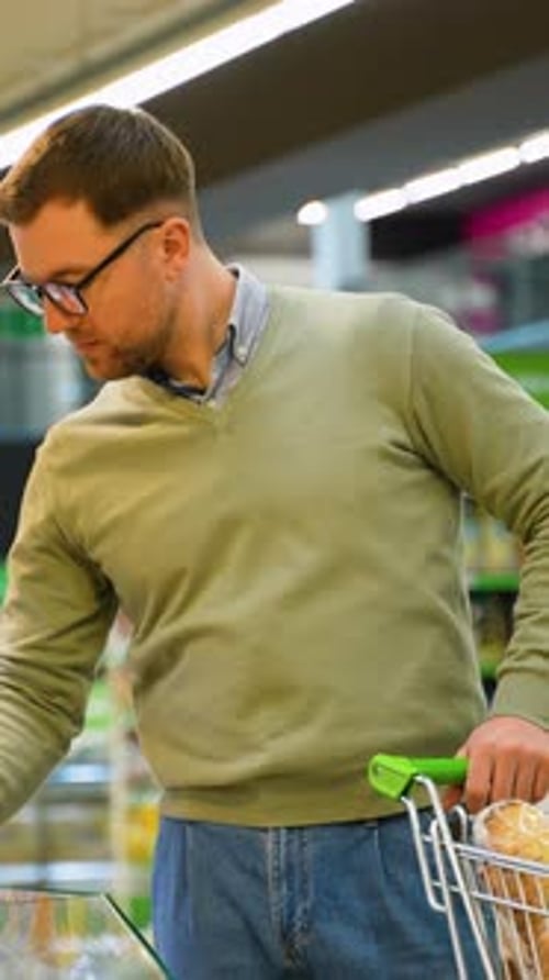 Man Selecting Discounted Cheese at the Supermarket