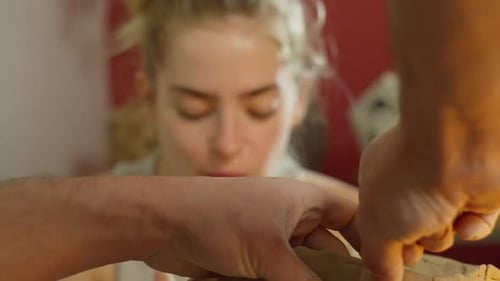 Hands Shaping Clay Pot with Assistance
