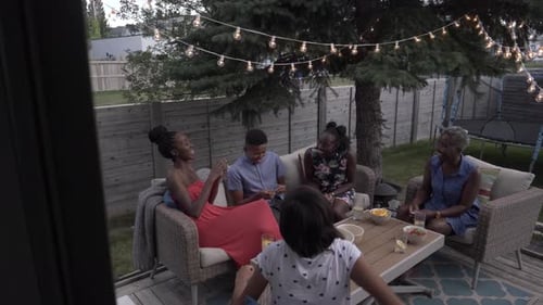 Family Relaxing on Patio Decorated with String Lights